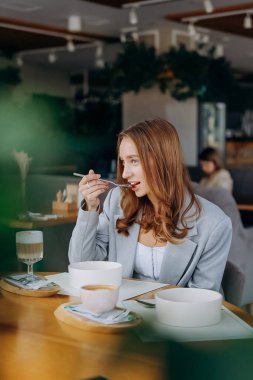 Genç ve çekici bir kadın kafe veya restoran arka planında lezzetli yemekler yemekten hoşlanır. Yüksek kalite fotoğraf