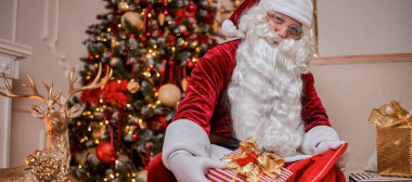 Evde çocuklara hediye dolu kırmızı çantalı Noel Baba. Yeni yıl ve Mutlu Noeller konsepti 