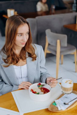 Genç ve çekici bir kadın kafe veya restoran arka planında lezzetli yemekler yemekten hoşlanır. Yüksek kalite fotoğraf