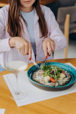 Genç ve çekici bir kadın kafe veya restoran arka planında lezzetli yemekler yemekten hoşlanır. Yüksek kalite fotoğraf