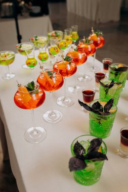Bir etkinlikte kokteyl bardakları ve içkilerle hoş geldin içkisi. Düğün masasında alkollü içecekler.
