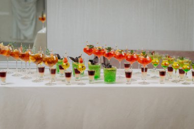 Bir etkinlikte kokteyl bardakları ve içkilerle hoş geldin içkisi. Düğün masasında alkollü içecekler.