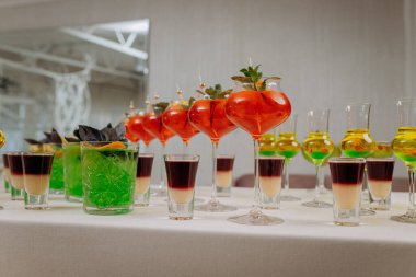 Bir etkinlikte kokteyl bardakları ve içkilerle hoş geldin içkisi. Düğün masasında alkollü içecekler.