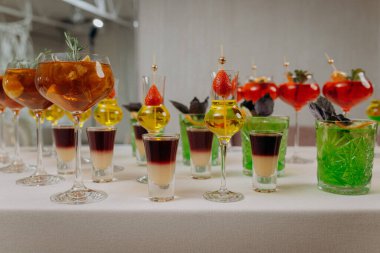 Bir etkinlikte kokteyl bardakları ve içkilerle hoş geldin içkisi. Düğün masasında alkollü içecekler.