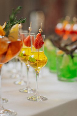 Bir etkinlikte kokteyl bardakları ve içkilerle hoş geldin içkisi. Düğün masasında alkollü içecekler.