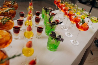 Bir etkinlikte kokteyl bardakları ve içkilerle hoş geldin içkisi. Düğün masasında alkollü içecekler.