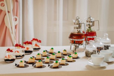 Tatlı çikolatalı tatlı ve şık limonata bankaları olan kekler ve festival masasında çay.