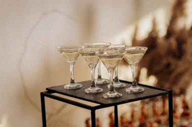 Bir etkinlikte kokteyl bardakları ve içkilerle hoş geldin içkisi. Düğün masasında alkollü içecekler.