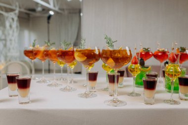 Bir etkinlikte kokteyl bardakları ve içkilerle hoş geldin içkisi. Düğün masasında alkollü içecekler.