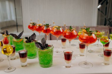 Bir etkinlikte kokteyl bardakları ve içkilerle hoş geldin içkisi. Düğün masasında alkollü içecekler.