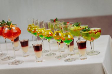 Bir etkinlikte kokteyl bardakları ve içkilerle hoş geldin içkisi. Düğün masasında alkollü içecekler.