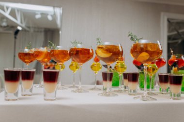 Bir etkinlikte kokteyl bardakları ve içkilerle hoş geldin içkisi. Düğün masasında alkollü içecekler.