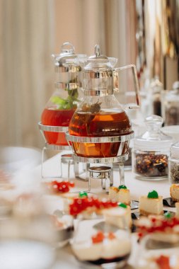 Tatlı çikolatalı tatlı ve şık limonata bankaları olan kekler ve festival masasında çay.