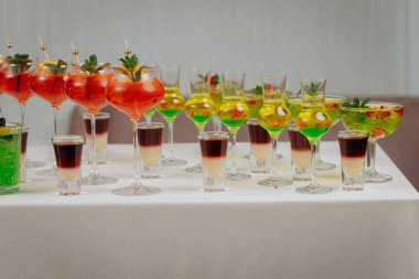 Bir etkinlikte kokteyl bardakları ve içkilerle hoş geldin içkisi. Düğün masasında alkollü içecekler.