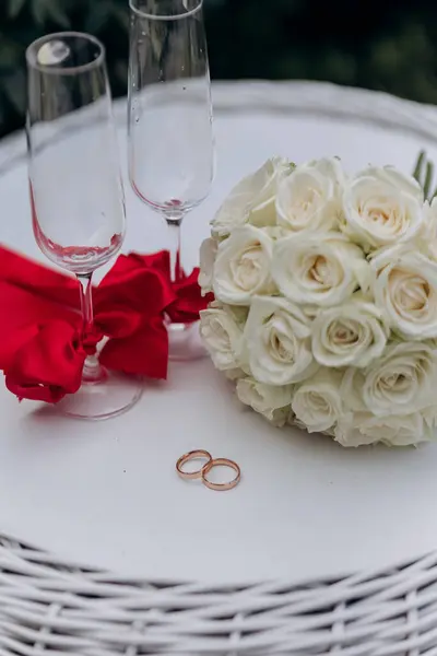 Stock image Elegant wedding setting with white roses, wedding rings, and champagne glasses, perfect for celebration. High quality photo