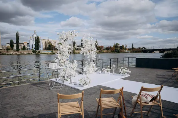 stock image Elegant outdoor wedding ceremony setup with white floral arrangements by the water. High quality photo