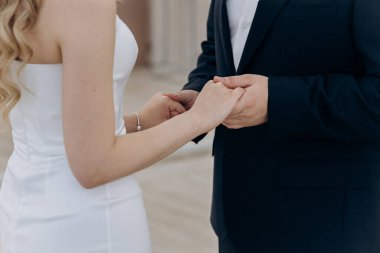 Nikah yüzükleriyle gelin ve damat, düğün törenlerinde el ele tutuşup birbirlerine dokunuyorlar. Yüksek kalite fotoğraf