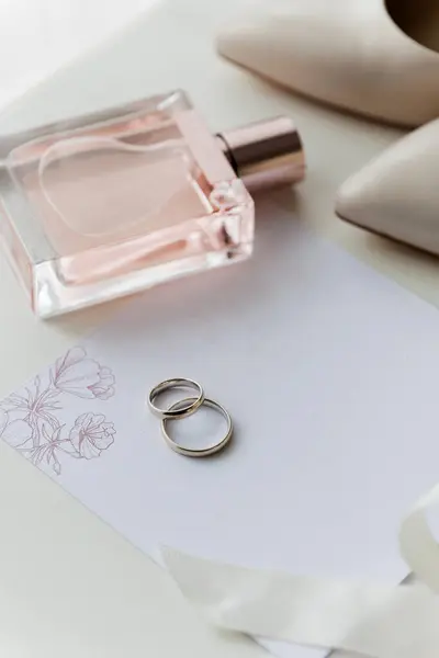 stock image Brides wedding essentials: heels, bouquet, rings, perfume, and invitation on a white table, elegant preparation. High quality photo