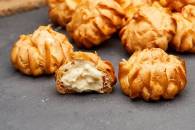 Lezzetli krema dolu profiteroller, altın ve çıtır, tatlı için mükemmel.