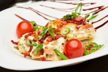 Pastırmalı tavuk göğsü, taze domates ve gurme yemeği sunumları için bitkiler. Yüksek kalite fotoğraf