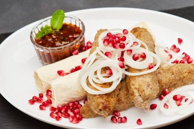 Geleneksel ızgara kebap. Nar, soğan ve baharatlı sos. Lezzetli mutfak deneyimi için. Yüksek kalite fotoğraf