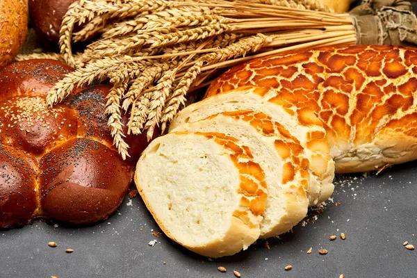 stock image Assortment of freshly baked bread loaves with wheat stalks, tradition and artisanal baking. High quality photo