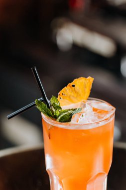 Ananas garnitürlü tropikal kokteyl, yaz havası ve bar sahneleri için mükemmel.