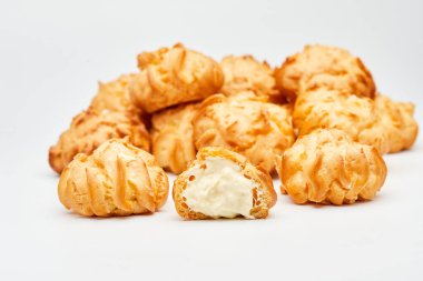 Lezzetli krema dolu profiteroller. Koyu bir sayfaya dizilmiş. Tatlı severler için mükemmel.