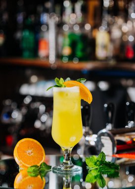 Refreshing yellow citrus cocktail with orange slice garnish and fresh mint, perfect for summer. High quality photo clipart