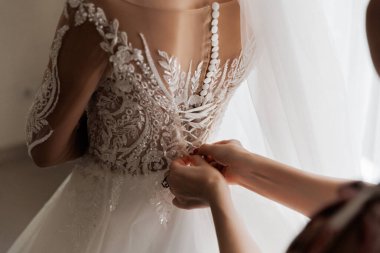 Gelinin özel gününe hazırlanırken gelinlik yakın plan, karmaşık dantel detaylarını gözler önüne seriyor. Yüksek kalite fotoğraf