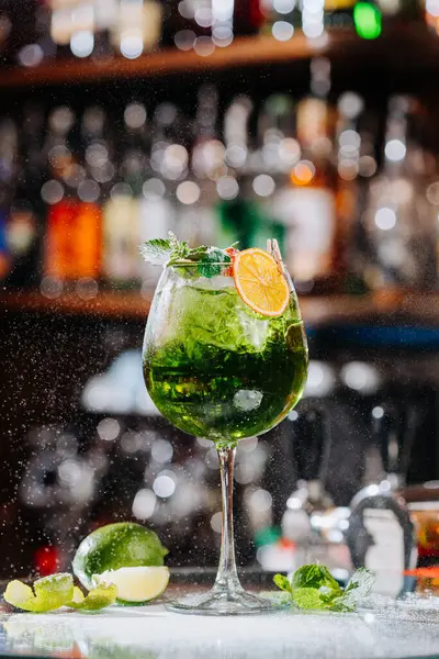 stock image Vibrant green cocktail with lime and mint garnish, perfect for refreshing summer moments 