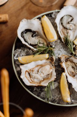 Limon dilimleri ve biberiyeyle servis edilen taze istiridye. Gurme deniz ürünleri aşıkları için mükemmel. Yüksek kalite fotoğraf
