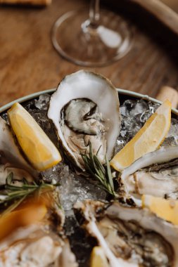 Limon dilimleri ve biberiyeyle servis edilen taze istiridye. Gurme deniz ürünleri aşıkları için mükemmel. Yüksek kalite fotoğraf