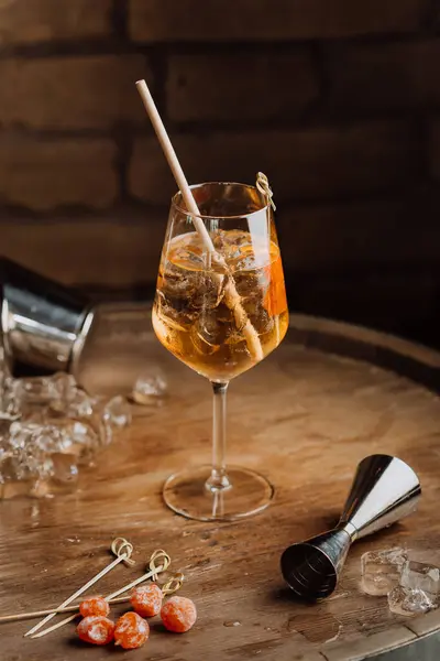 stock image Elegant cocktail on a rustic wooden table with garnishes and ice, perfect for upscale bars. High quality photo