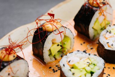 Nefis bir sunum için susamlı ve kırmızı biberli baharatlı soslu suşi. Yüksek kalite fotoğraf