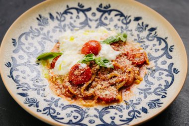 Kiraz domatesli İtalyan makarnası, burrata, ve taze fesleğen - aşıklar için gurme yemeği. Yüksek kalite fotoğraf