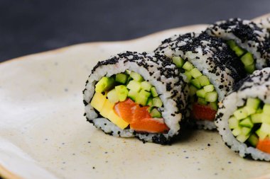 Sushi rolls with black caviar and fresh vegetables, ideal for Japanese cuisine and food photography. High quality photo clipart