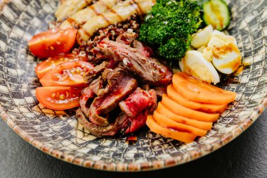 Biftek, sebze ve yumurtalı canlı kinoa kasesi dengeli ve besleyici bir yemek için mükemmel. Yüksek kalite fotoğraf