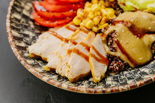 stock image Healthy quinoa bowl with chicken, vegetables, beans, and dressing for a nutritious and balanced meal. High quality photo