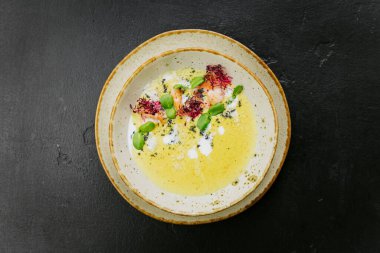Karides, mikro yeşillik ve sanatsal sunumlu kremalı gurme çorbası. Zarif bir yemek tabağı. Yüksek kalite fotoğraf