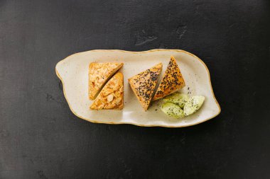 Badem ve çekirdekli taze pişmiş zanaatkar ekmek dilimleri, tabakta tereyağı ile servis edilir. Yüksek kalite fotoğraf