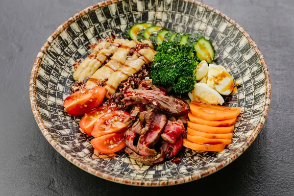 stock image Protein-packed quinoa bowl with steak, veggies, and eggs for a balanced, nutritious meal. High quality photo