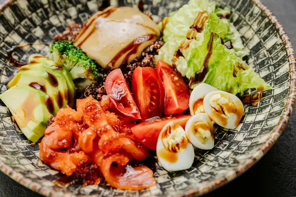 stock image Colorful salad bowl with fresh vegetables, avocado, eggs, and sauce - healthy and vibrant meal. High quality photo