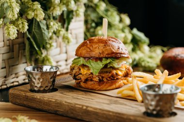 Peynirli, marullu ve turşulu domuz etli hamburger ve yanında patates kızartması. Yüksek kalite fotoğraf