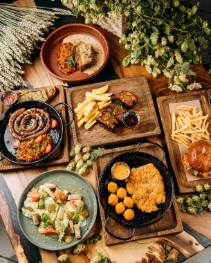 Sosis, domuz pirzolası, salata, şnitzel ve kızarmış hamburgerli çeşitli gurme yemekleri. Yüksek kalite fotoğraf