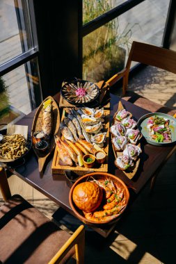 Seafood spread on restaurant table with assorted grilled fish, oysters, prawns, and appetizers. High quality photo clipart