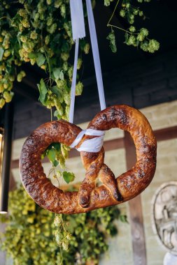 Traditional Bavarian pretzels displayed on stands with fresh hops, Oktoberfest and German cuisine. High quality photo clipart