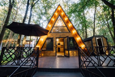 Açık verandası, saunası ve jakuzisi olan rahat bir kulübe. Huzurlu bir orman inzivası ile çevrili. Yüksek kalite fotoğraf