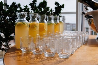 Cam sürahiler içinde taze limonata ve masaya yerleştirilmiş boş bardaklar, yaz etkinlikleri veya yemek servisi. Yüksek kalite fotoğraf