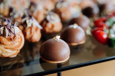 Gurme çikolatalı tatlılar ve lezzetli prosciutto aperatifleri etkinlik ya da yemek servisi için sergileniyor. Yüksek kalite fotoğraf